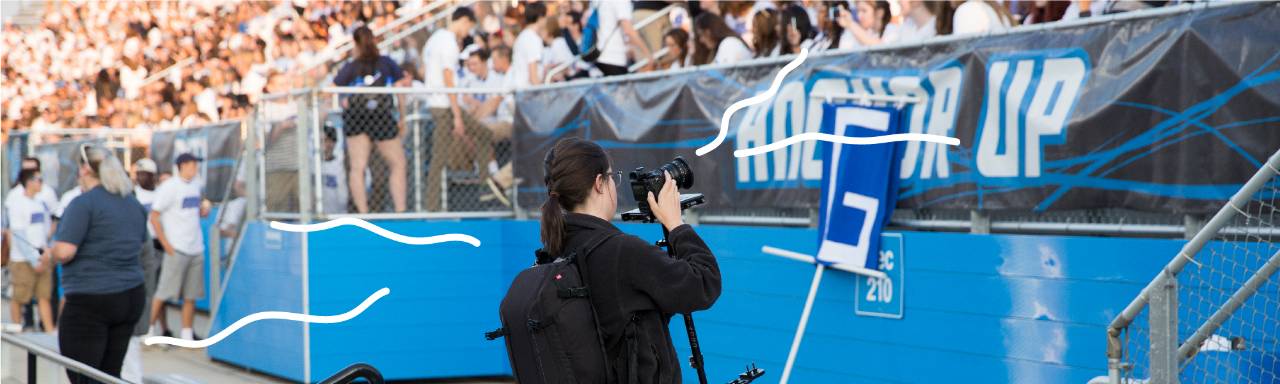 A student taking photos of students in Lubbers Stadium